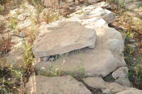 Grossi blocchi di pietra accatastati, probabilmente facevano parte del dolmen.